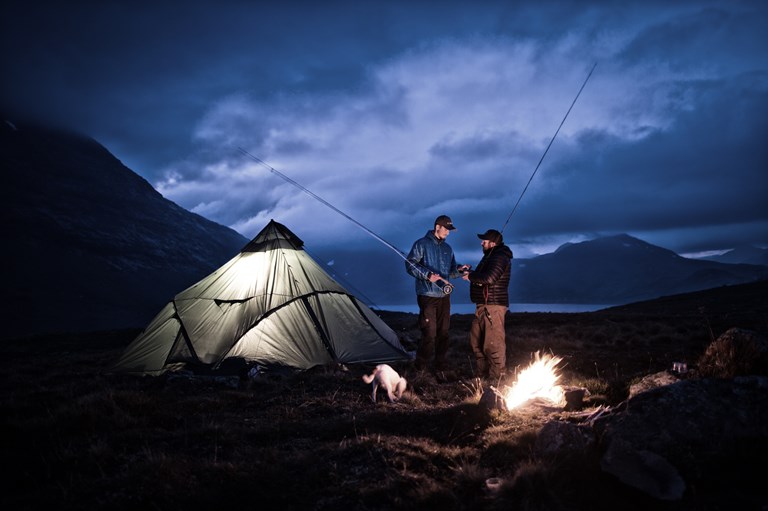 Et bål, et telt, ei bikkje og to fluefiskere i djup diskusjon om utstyrsvalg. Jotunheimen spiller rollen som kulisser. Foto: Ida Ask.