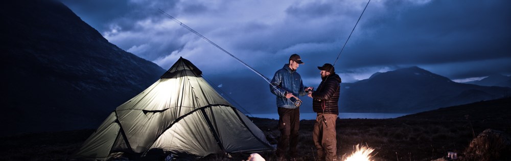 Et bål, et telt, ei bikkje og to fluefiskere i djup diskusjon om utstyrsvalg. Jotunheimen spiller rollen som kulisser. Foto: Ida Ask.